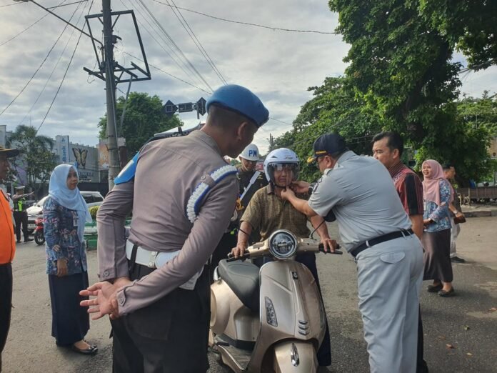 Berlalu Lintas Dengan Membagikan Helm